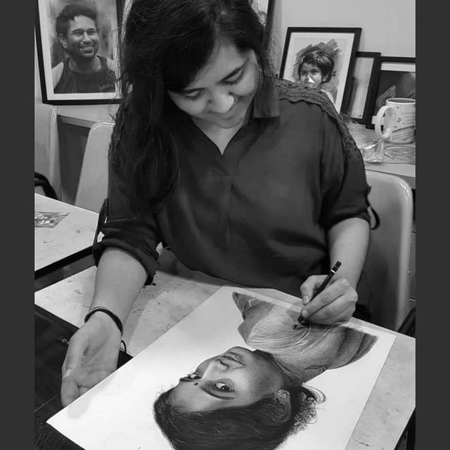 Komal Thoria Indian artist drawing a charcoal portrait